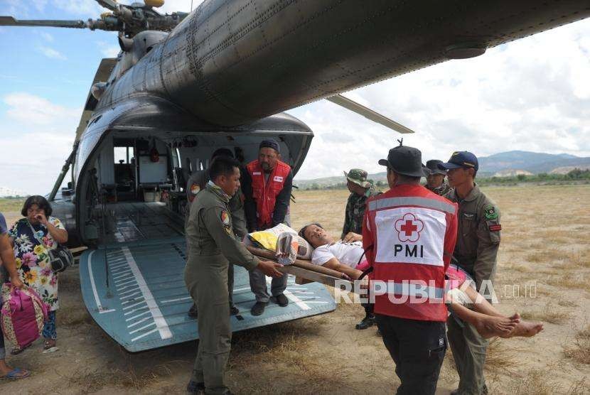 Evakuasi Korban Gempa : Seorang korban gempa asal Kowali diturunkan seusai mendarat dengan menggunakan helikopter TNI AD di Lapangan Udara Mutiara SIS Al jufri, Palu, Sulawesi Tengah, Senin (8/10).