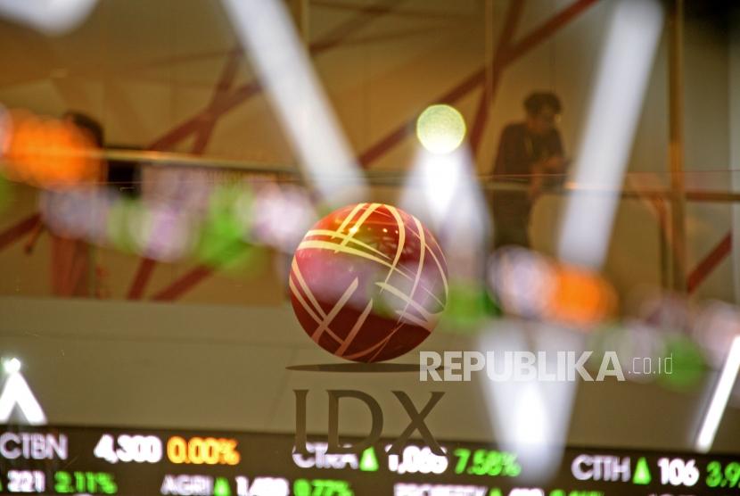 Pegawai melintas di dekat layar pergerakan saham di Bursa Efek Indonesia, Jakarta, Kamis (29/11).