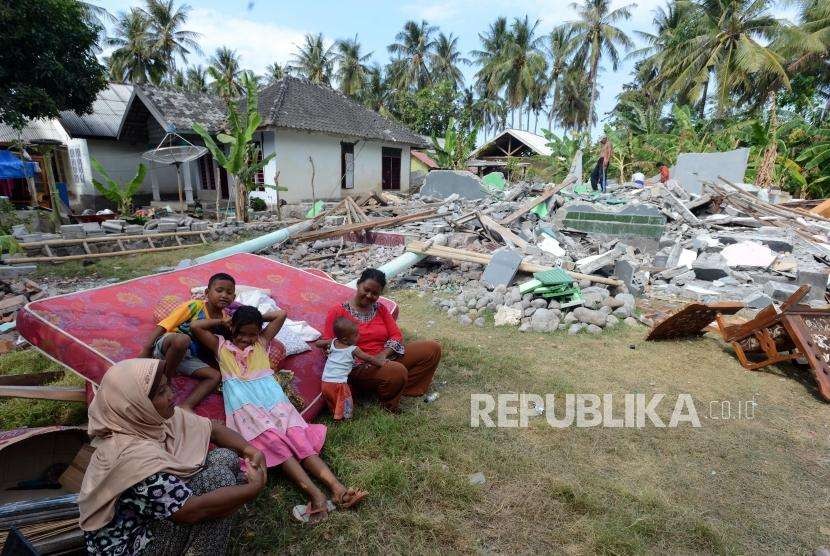 Sejumlah warga beraktivitas di dekat puing-puing bangunan di Sambelia, Lombok Timur, Nusa Tenggara Barat, Selasa (21/8).