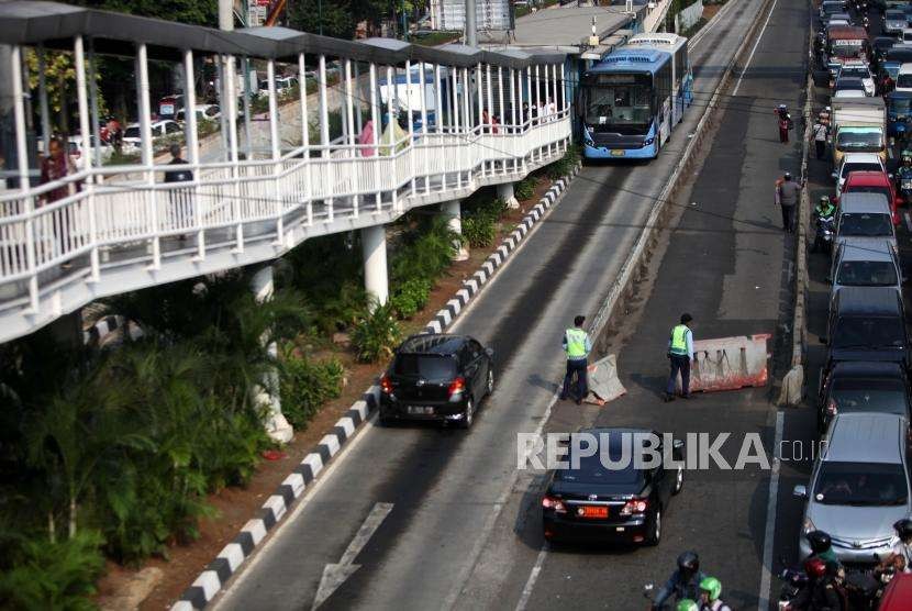 Kendaran mobil dipaksa berjalan mundur saat menerobos sekaligus melawan arah jalur Transjakarta di Kawasan Jalan Matraman, Jakarta, Selasa (4/9).