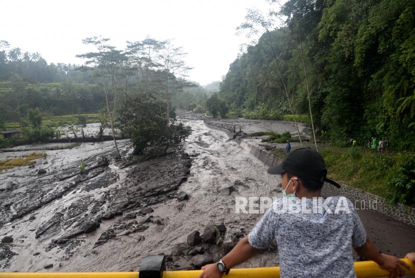 Aliran Lahar Dingin Meluas. Warga menonton lahar dingin dari Gunung Agung yang mulai memenuhi Sungai Yeh Sah di Rendang, Bali, Rabu (29/11).