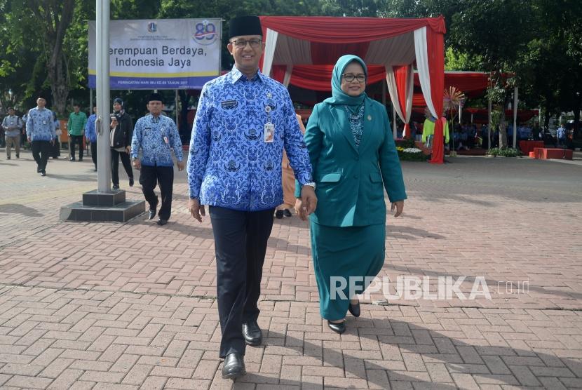 Gubernur DKI Jakarta Anies Baswedan bersama Isteri berjalan untuk menyalami peserta upacara peringatan hari ibu ke-89 di Lapangan IRTI Monas, Jakarta, Jumat (22/12).