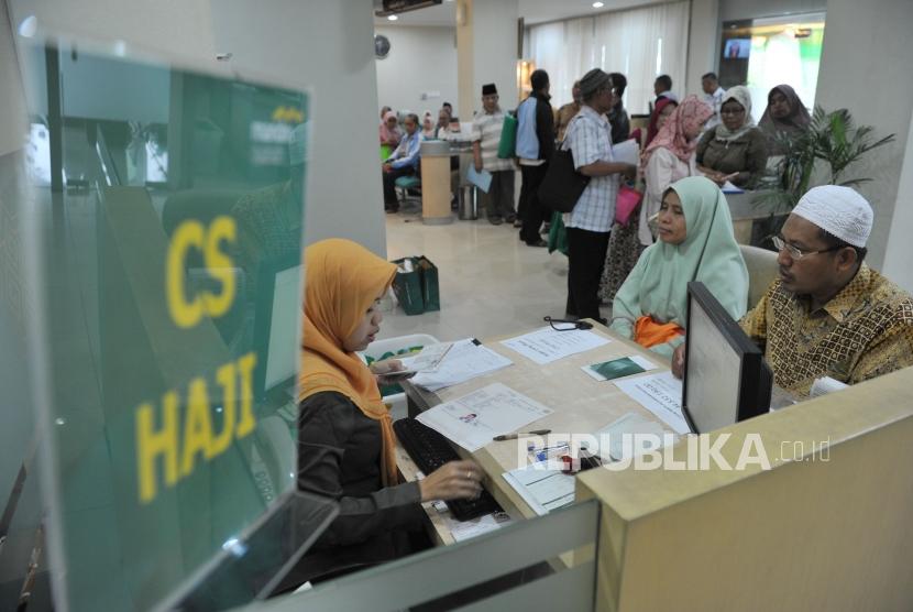 Petugas Bank Mandiri Syariah melayani calon jemaah haji yang melakukan pelunasan Biaya Penyelenggaran Ibadah Haji (BPIH) di Kantor Cabang Mandiri Syariah Area Bekasi, di Bekasi, Jawa Barat, Senin (16/4).