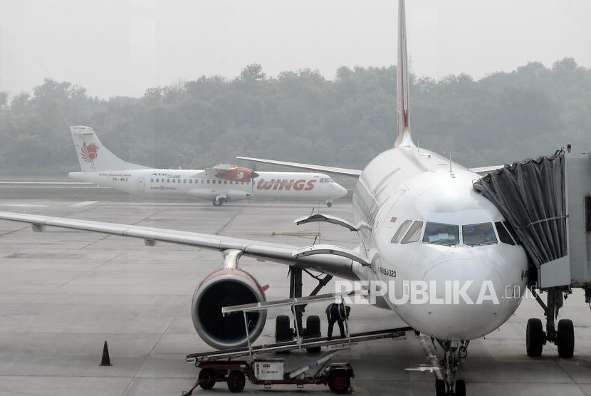 Sebuah pesawat melintasi landasan pacu yang diselimuti kabut asap di Bandara Sultan Syarif Kasim II Pekanbaru, Riau, Sabtu (21/9).
