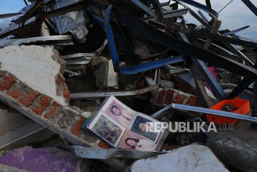 Sebuah album foto tergeletak di antara puing-puing bangunan rumah di wilayah Petobo, Kabupaten Sigi, Sulawesi Tengah, Kamis (11/10).