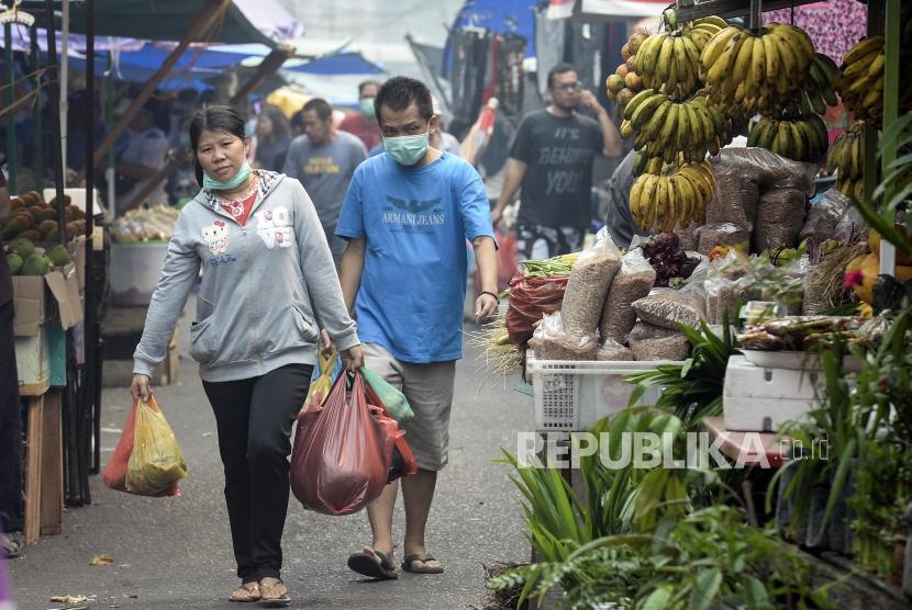 Warga memakai masker saat membawa kantung belanja di Pasar Sago, Pekanbaru, Riau, Selasa (18/9).