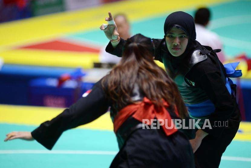 Pesilat Indonesia Pipiet Kamelia (pita biru) bertanding melawan Pesilat Singapura Nurul Suhaila Mohd Saiful pada babak perempat final cabang pencak silat putra kelas D 60-65 kg Asian Games 2018 di Padepokan Pencak Silat TMII, Jakarta, Jumat (24/8).
