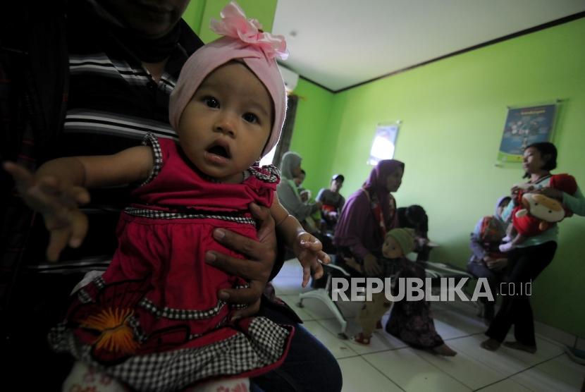 Sejumlah warga mengantre sebelum melakukan imunisasi difteri untuk anaknya di Puskemas Cimanggis, Depok, Jawa Barat, Rabu (6/12).