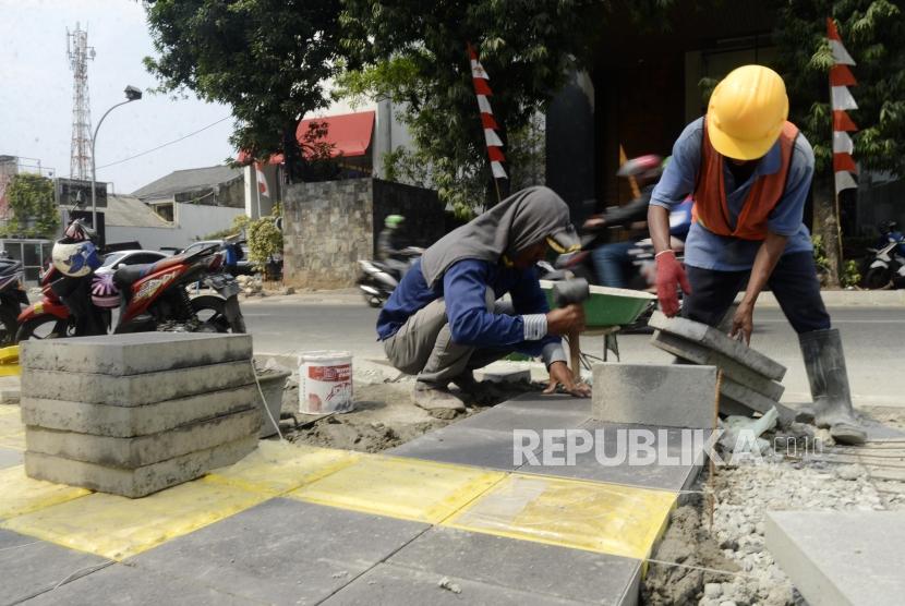 Pekerja saat menyelesaikan proyek revitalisasi trotoar di kawasan Kemang, Jakarta, Rabu (7/8).