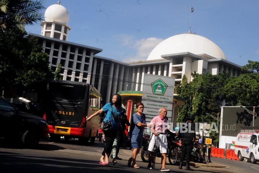 MUI DKI Pertanyakan Indeks Kerukunan Jakarta di Bawah Papua. Foto ilustrasi sejumlah jemaah Gereja Katedral menyeberangi jalan usai memarkirkan kendaraannya di Masjid Istiqlal, Jakarta.