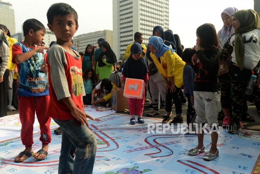 Anak-anak saat bermain permainan tradisional saat Hari Bebas Kendaraan Bermotor (HBKB) di Jalan Jenderal Sudirman, Jakarta, Ahad (18/11).