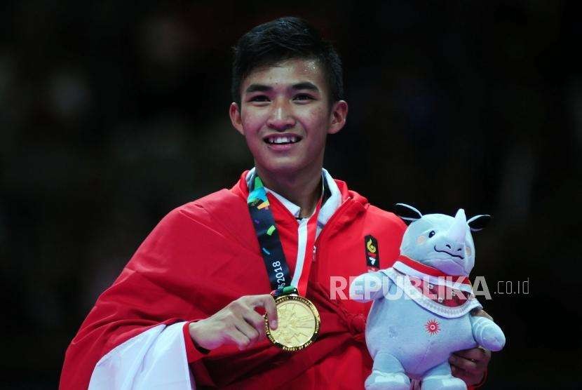 Karateka Indonesia Arrosyiid Rifki Ardiansyah memperlihatkan medali usai memenangkan pertandingan cabang olahraga karate Asian Games 2018 kategori kumite 60 kilogram di JCC Plennary Hall, Jakarta, Ahad (26/8).