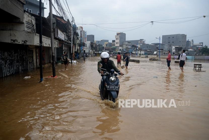 Warga melintasi genangan saat banjir melanda ruas jalan Jatinegara Barat, Jakarta, (ilustrasi)