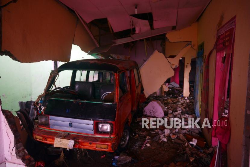 Mobil masuk ke ruangan rumah pasca bencana tsunami di Desa Way Uli, Kalianda, Lampung Selatan, Selasa (25/12).