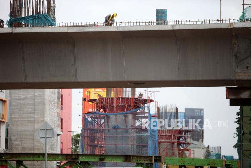 Pekerja menyelesaikan pembangunan proyek Light Rail Transit (LRT) Atau kereta api ringan dikawasan Kelapa Gading, Jakarta, Ahad (14/1).