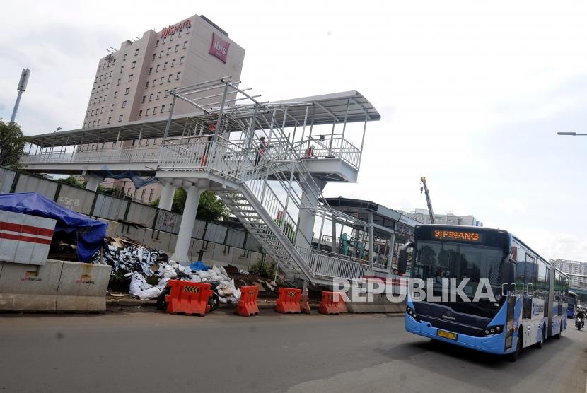 Bus Transjakarta melintas didekat pembangunan Halte Busway Transjakarta BNN di kawasan Cawang, Jakarta, Jumat (9/3).