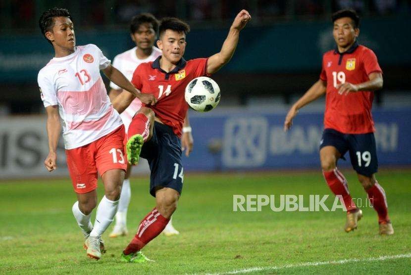 Pesepak bola Indonesia  Febri Hariyadi berusaha melewati pemain Laos pada laga penyisihan Grup A cabang sepak bola Asian Games 2018 di Stadion Patriot, Bekasi, Jumat(17/8).