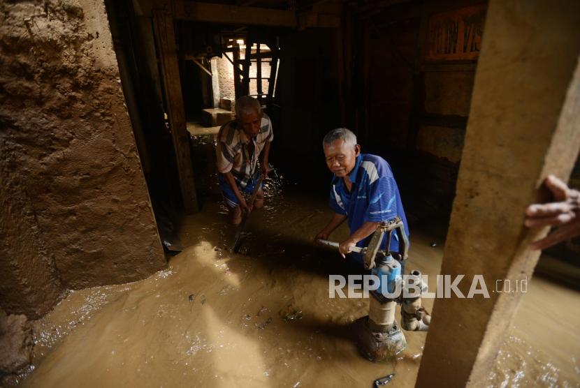 Warga saat membersihkan sisa banjir yang menggenangi kawasan Kampung Melayu, Jakarta, Senin (12/11).