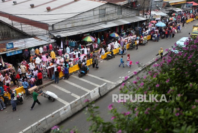 Pedagang melayani pembeli di trotoar kawasan Tanah Abang, Jakarta, Kamis (14/12).