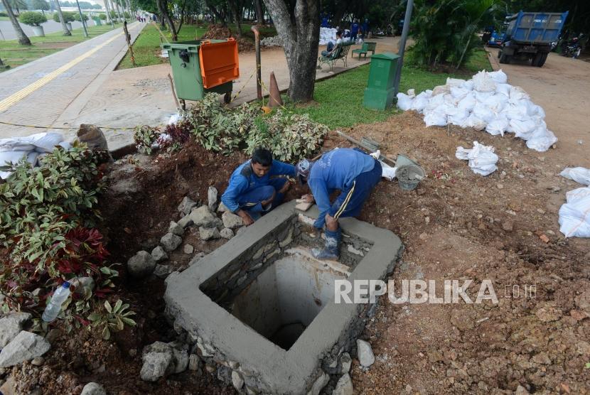 Sumur Resapan. Petugas Dinas Sumber Daya Air saat menyelesaikan pembangunan sumur resapan di kawasan Monas, Jakarta, Selasa (26/2).