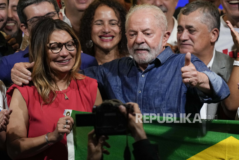 Sambil merangkul istrinya Rosangela, mantan Presiden Brasil Luiz Inacio Lula da Silva mengacungkan jempol setelah mengalahkan pejawat Jair Bolsonaro dalam pemilihan presiden untuk menjadi presiden negara berikutnya, di Sao Paulo, Brasil, Ahad, 30 Oktober 2022. Lula menggandeng ekonom yang menstabilkan keuangan negaranya pada 1990-an. 