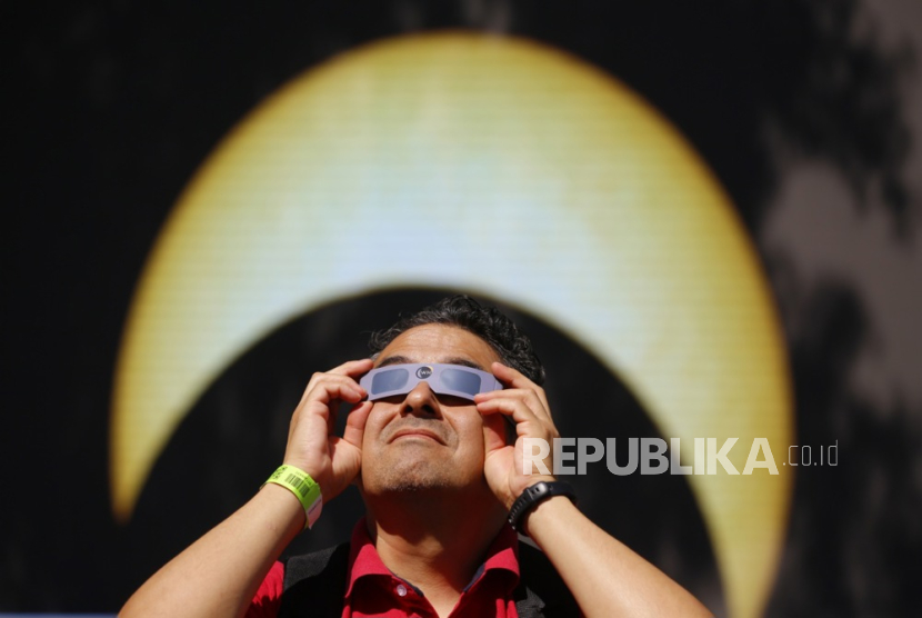 Seorang pria mengamati gerhana matahari cincin dari kota Guadalajara, di negara bagian Jalisco, Meksiko, Sabtu, (14/10/2023) 