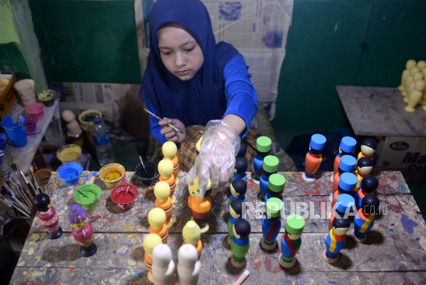 Pesanan Boneka Kayu Terhenti. Perajin mewarnai boneka kayu di Barokah Craft, Pakem, Sleman, Yogyakarta, Kamis (19/3). Otoritas Jasa Keuangan (OJK) optimistis porsi kredit UMKM naik menjadi 30 persen dapat terealisasi pada tahun ini.
