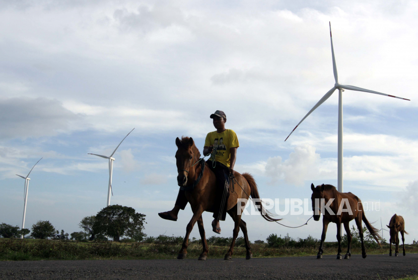 Warga menunggangi kuda saat melintas di area Pembangkit Listrik Tenaga Bayu (PLTB) Tolo di Kabupaten Jeneponto, Sulawesi Selatan. Kementerian ESDM mencatat bauran energi baru dan terbarukan (EBT) baru 11,51 persen pada kuartal pertama 2020.