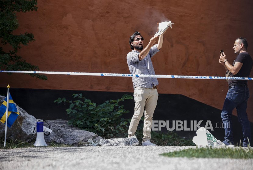 Seorang imigran irak, Salwan Momika menyobek lembaran halaman Alquran kemudian membakarnya di depan masjid Stockholm, Rabu (28/6/2023).