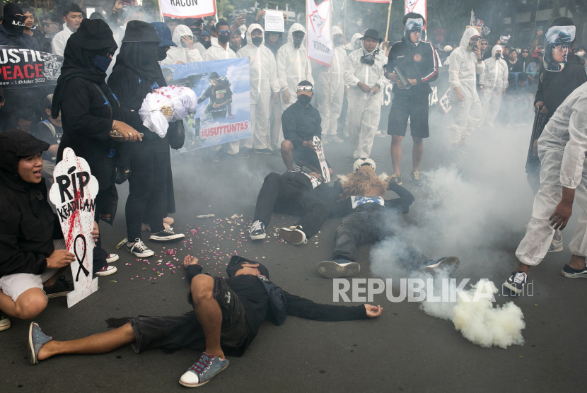  Para pengunjuk rasa menggunakan bom asap saat mereka melakukan aksi yang menggambarkan para korban penyerbuan sepak bola 1 Oktober, dalam rapat umum memperingati 40 hari sejak tragedi itu, di Malang, Jawa Timur, Kamis (10/11/2022). 