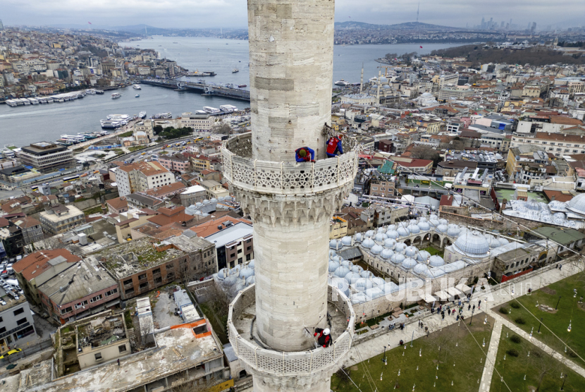 Pekerja melakukan pemasangan pesan lampu di puncak salah satu menara Masjid Suleymaniye di Istanbul, Turki, Rabu, (6/3/ 2024).