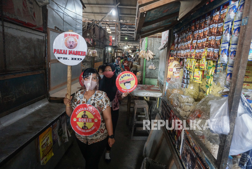 Petugas pasar berkeliling dengan membawa poster himbauan untuk mengenakan masker (ilustrasi). Asosiasi Pedagang Pasar Seluruh Indonesia (APPSI) meminta pemerintah daerah (pemda) meringankan biaya retribusi atau uang karcis bagi pedagang pasar.
