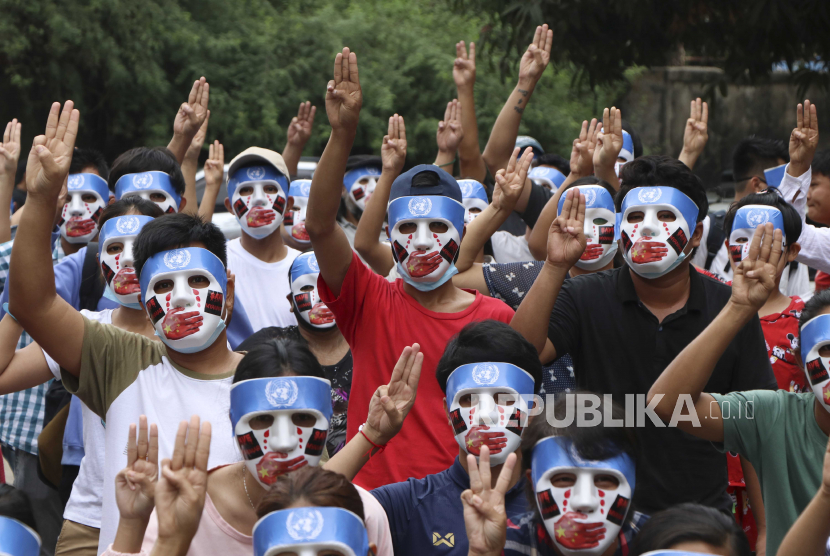 Demonstran muda menunjukkan simbol perlawanan tiga jari selama serangan topeng anti-kudeta di Yangon, Myanmar, Minggu, 4 April 2021. Ancaman kekerasan mematikan dan penangkapan pengunjuk rasa gagal menekan demonstrasi harian di seluruh Myanmar yang menuntut militer mundur. dan memulihkan pemerintahan yang dipilih secara demokratis.
