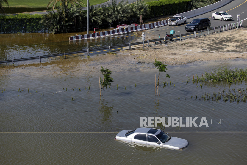 Sebuah kendaraan yang ditinggalkan berdiri di tengah air banjir akibat hujan lebat di Dubai, Uni Emirat Arab, Kamis, (18/4/2024). 