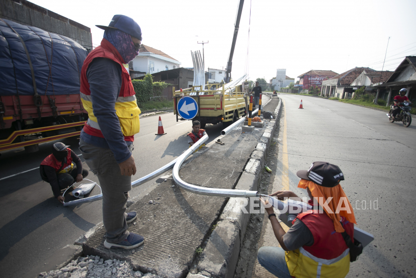 Pekerja menyelesaikan pemasangan lampu Penerangan Jalan Umum (PJU) (Ilustrasi)