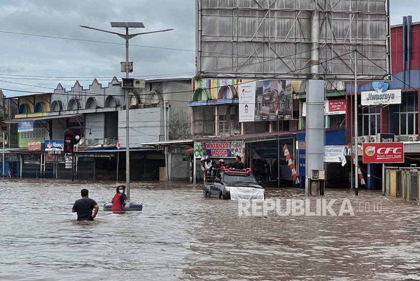 Sejumlah warga menaiki mobil saat melintasi jalan raya yang terendam banjir di Sintang, Kalimantan Barat, Rabu (10/11/2021). BNPB mencatat terdapat sekitar 35.117 rumah di 12 kecamatan di daerah setempat yang terendam banjir akibat tingginya curah hujan di wilayah hulu selama tiga pekan terakhir. 