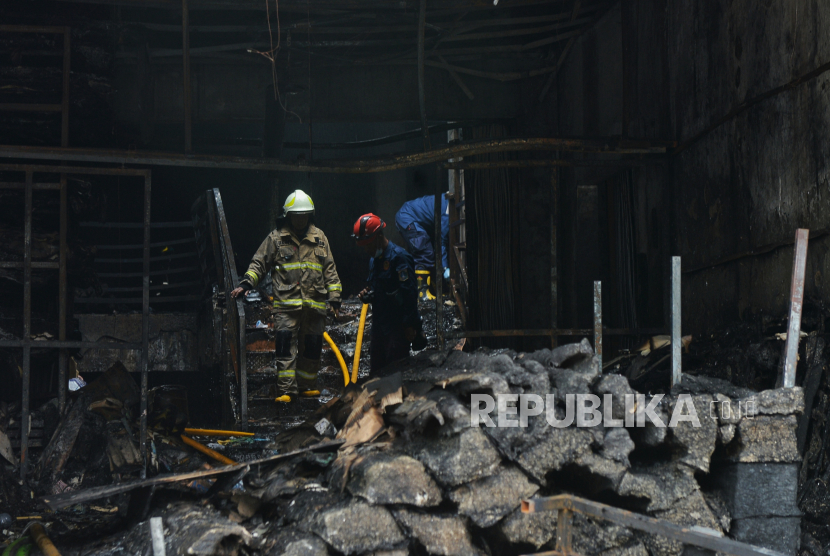 Petugas Penanggulangan Kebakaran dan Penyelamatan (Gulkarmat) DKI Jakarta melakukan pendinginan sisa kebakaran di Jalan Mampang Prapatan, Jakarta Selatan, Jumat (19/4/2024). Kebakaran yang menghanguskan toko bingkai tersebut terjadi pada Kamis (18/4) kemarin, sekitar pukul 19.30 WIB yang menewaskan sebanyak tujuh orang dan lima orang mengalami luka-luka. Ketujuh korban tersebut ditemukan tewas di lantai 2 saat petugas melakukan pendingina.