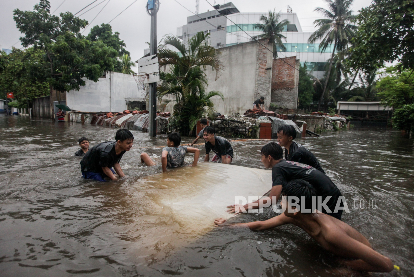 Anak-anak bermain air saat terjadi banjir di Pondok Karya, Mampang, Jakarta Selatan. Tim SAR gabungan menemukan jasad bocah, April (14 tahun) yang hanyut di Kali Mampang.