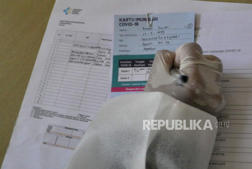 Petugas mengisi kartu tanda imunisasi Covid-19 tenaga kesehatan (Nakes) di Puskesmas Pandak I, Bantul, Yogyakarta, Rabu (3/2). Usulan vaksin dosis ketiga bagi nakes mengemuka.