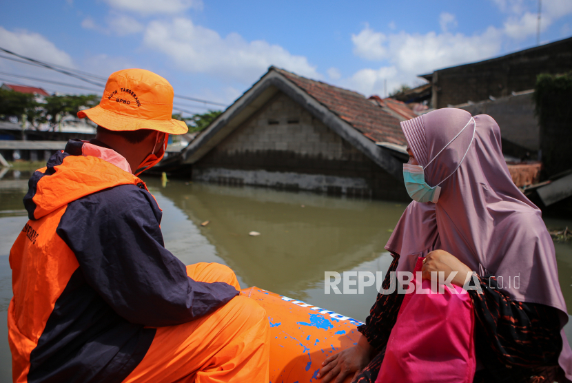 Petugas mengevakuasi warga menggunakan perahu karet saat banjir di Total Persada, Periuk, Kota Tangerang, Banten, Senin (22/2). Memasuki hari ketiga, kawasan tersebut masih terendam banjir hingga setinggi 2,5 meter akibat luapan Kali Leduk. 