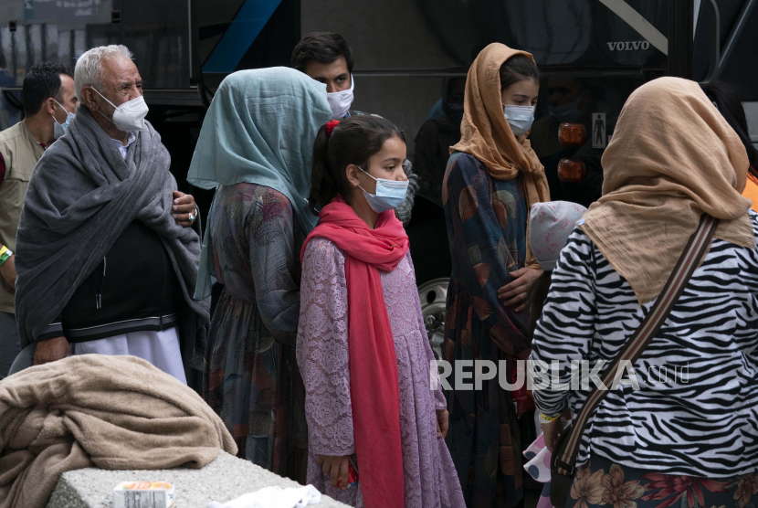 Keluarga yang dievakuasi dari Kabul, Afghanistan, menunggu untuk naik bus setelah mereka tiba di Bandara Internasional Washington Dulles, di Chantilly, Va, pada Minggu, 29 Agustus 2021.