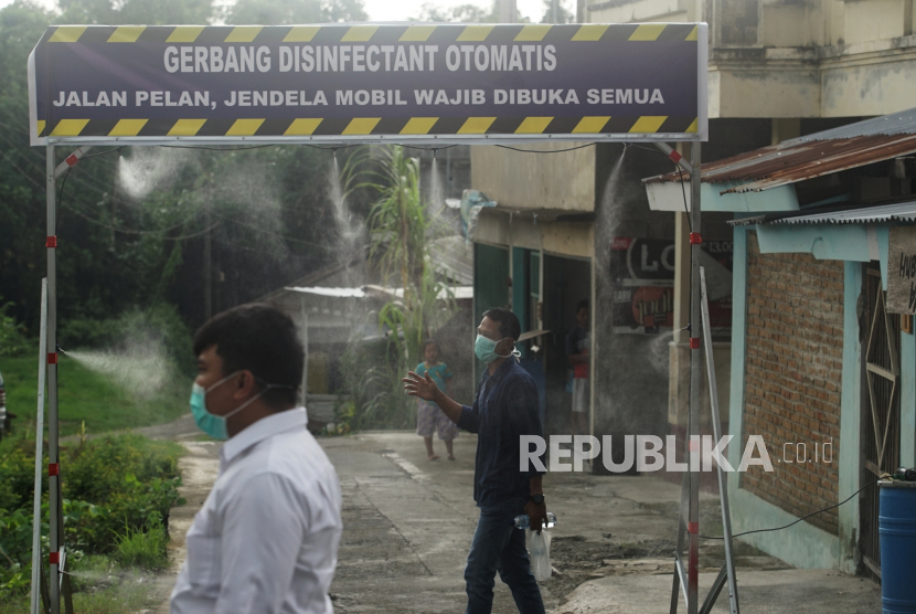 Warga membasuh diri di gerbang disinfektan yang terpasang di pintu masuk Kampung Kalipakis, Kasihan, Bantul, Daerah Istimewa Yogyakarta (DIY) untuk mencegah penyebaran virus corona (Covid-19).