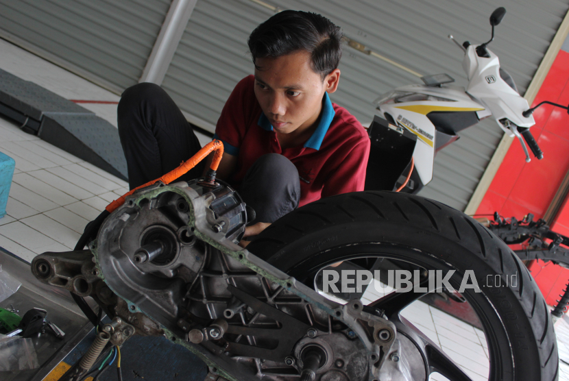 Seorang teknisi memasang komponen motor di sebuah bengkel di Kabupaten Bogor, Jawa Barat, Jumat (12/1/2024).