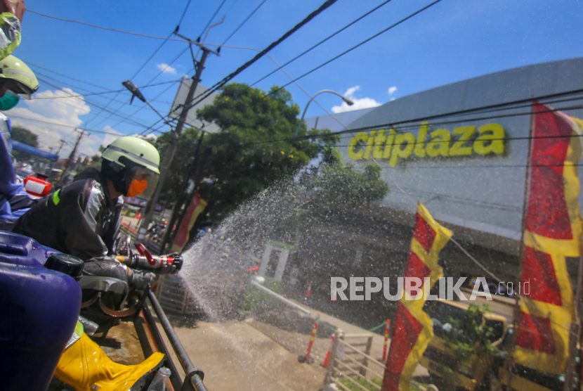 Petugas pemadam kebakaran menyemprotkan cairan disinfektan di Regency, Kabupaten Tangerang, Banten, Selasa (31/3/2020). Penyemprotan cairan disinfektan tersebut dilakukan serentak di 15 titik di Kabupaten Tangerang guna mencegah penyebaran COVID-19