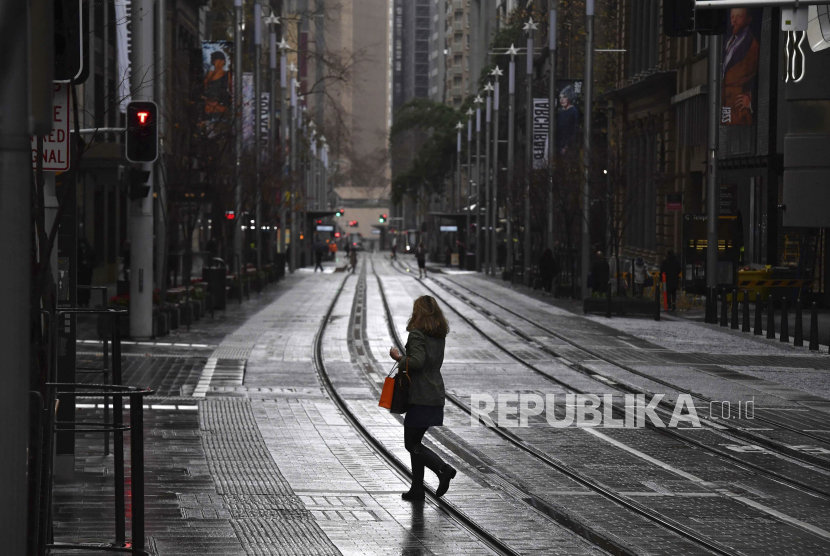 Seorang wanita melewati jalanan yang sepi di kawasan pusat bisnis Sydney, Australia, Selasa (29/6). Lebih dari lima juta orang di Sydney dan sekitarnya telah memberlakukan lockdown selama 14 hari untuk mengurangi penyebaran wabah virus Covid-19.  