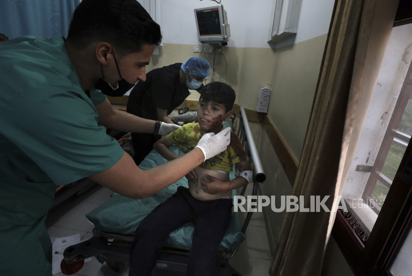 Seorang petugas medis merawat seorang bocah lelaki yang terluka setelah ledakan di Kota Beit Lahiya, Jalur Gaza, Palestina, pada Senin, 10 Mei 2021.