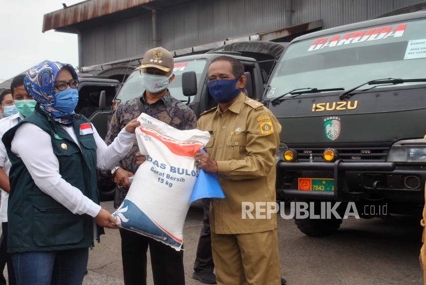 Bupati Bogor Ade Yasin (kiri) menyerahkan bantuan sosial beras kepada Kepala Desa Karehkel, Leuwiliang saat penyaluran bantuan sosial untuk masyarakat Kabupaten Bogor di Gudang Bulog, Dramaga, Kabupaten Bogor, Jawa Barat (ilustrasi)