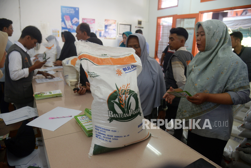 Petugas PT Pos merekam data warga saat penyaluran perdana bantuan pangan cadangan beras pemerintah tahun 2024 di kantor Pos Peukan Bada, Aceh Besar, Aceh, Rabu (31/1/2024). 