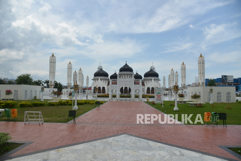 Seorang warga berjalan di halaman Masjid Raya Baiturrahman, Banda Aceh, Ahad (5/4/2020). Objek wisata religi Masjid Raya Baiturrahman yang juga merupakan salah situs sejarah itu sepi pengunjung pada hari libur dampak dari pandemi Corona Virus (COVID-19)