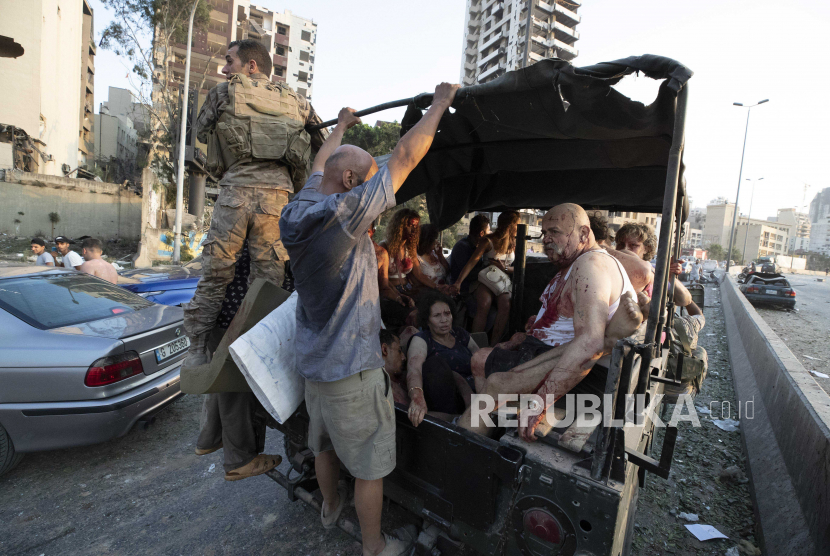 Warga yang terluka akibat ledakan dievakuasi dengan menggunakan mobil bak terbuka di Beirut, Lebanon, Selasa (4/8). AP Photo/Hassan Ammar